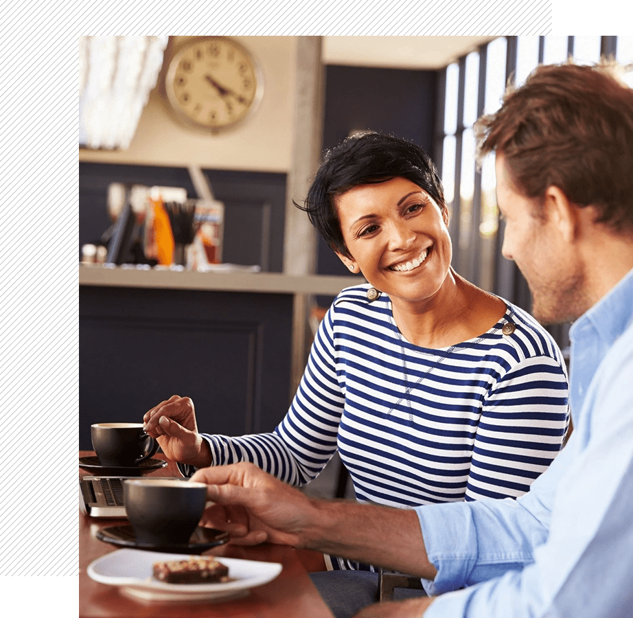 A man and woman sitting at a table with food.